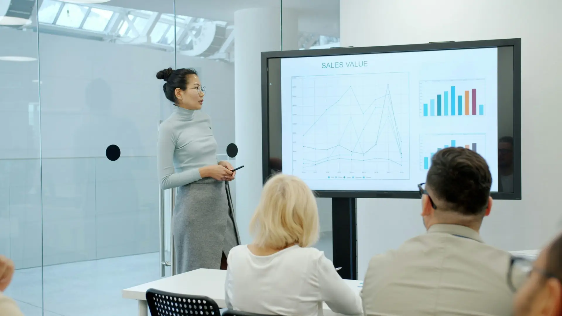 Business leader and technical team discussing AI cost-efficiency charts in a modern meeting room